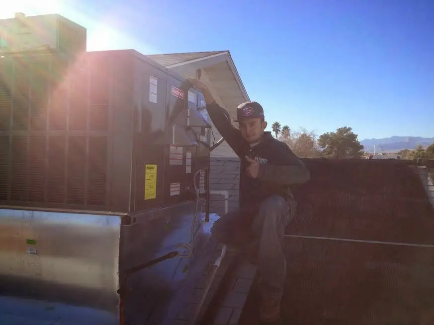 HVAC technician performing HVAC Inspection on a rooftop unit in Woodlake